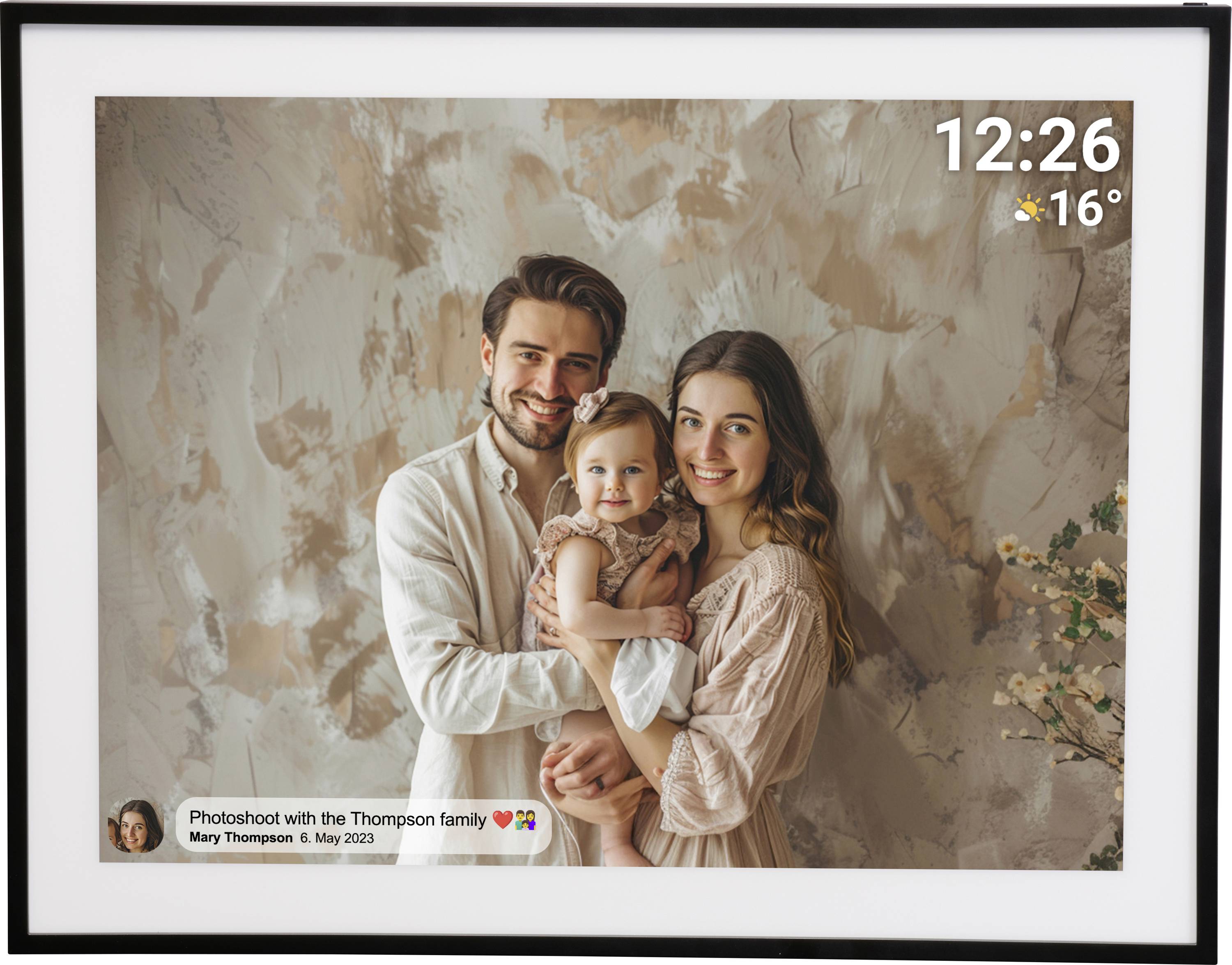 A smiling couple hold their toddler in front of a patterned wall. Time and weather displayed top right. Caption bottom left.