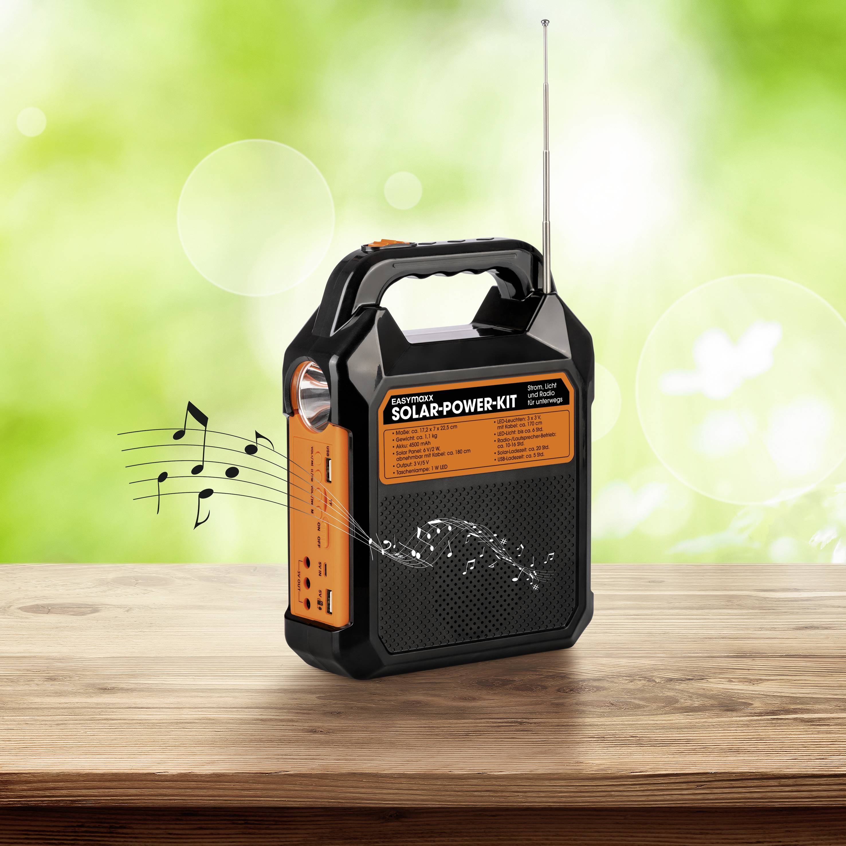 Solar-powered radio on a wooden table, musical notes seeming to emerge from speakers. Background is greenishly blurred.