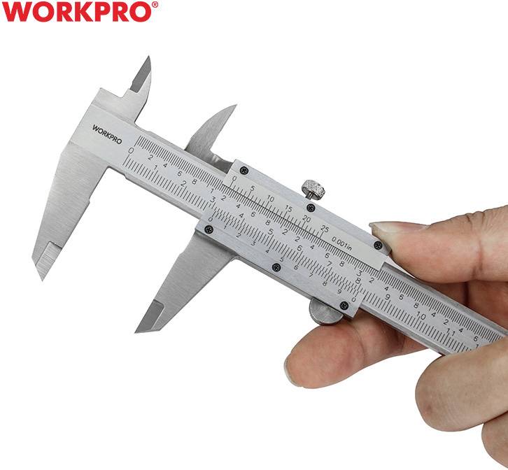 A hand is holding a silver calliper with a millimetre scale near the 
