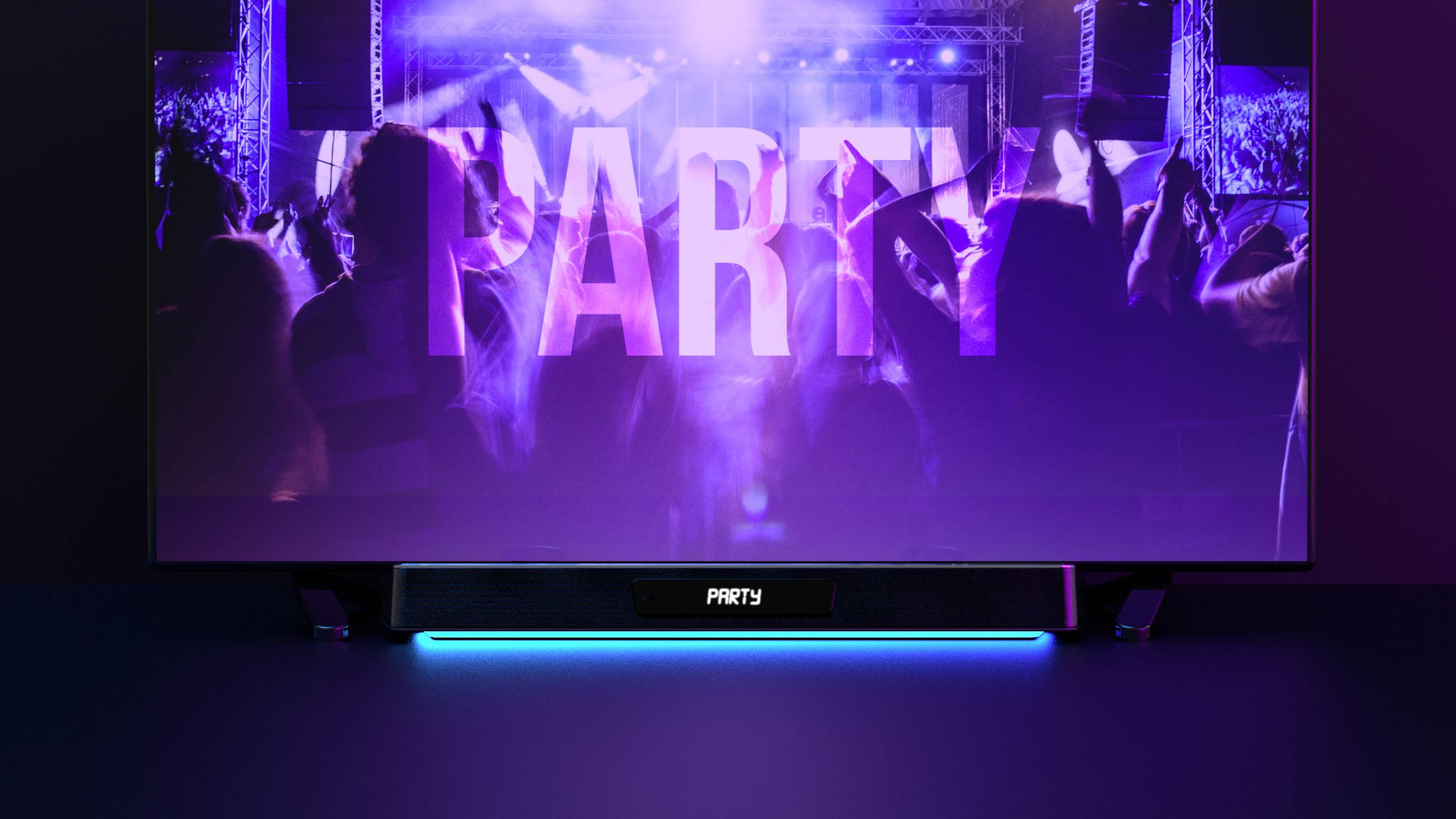 A crowd is dancing in front of a stage with large, illuminated 