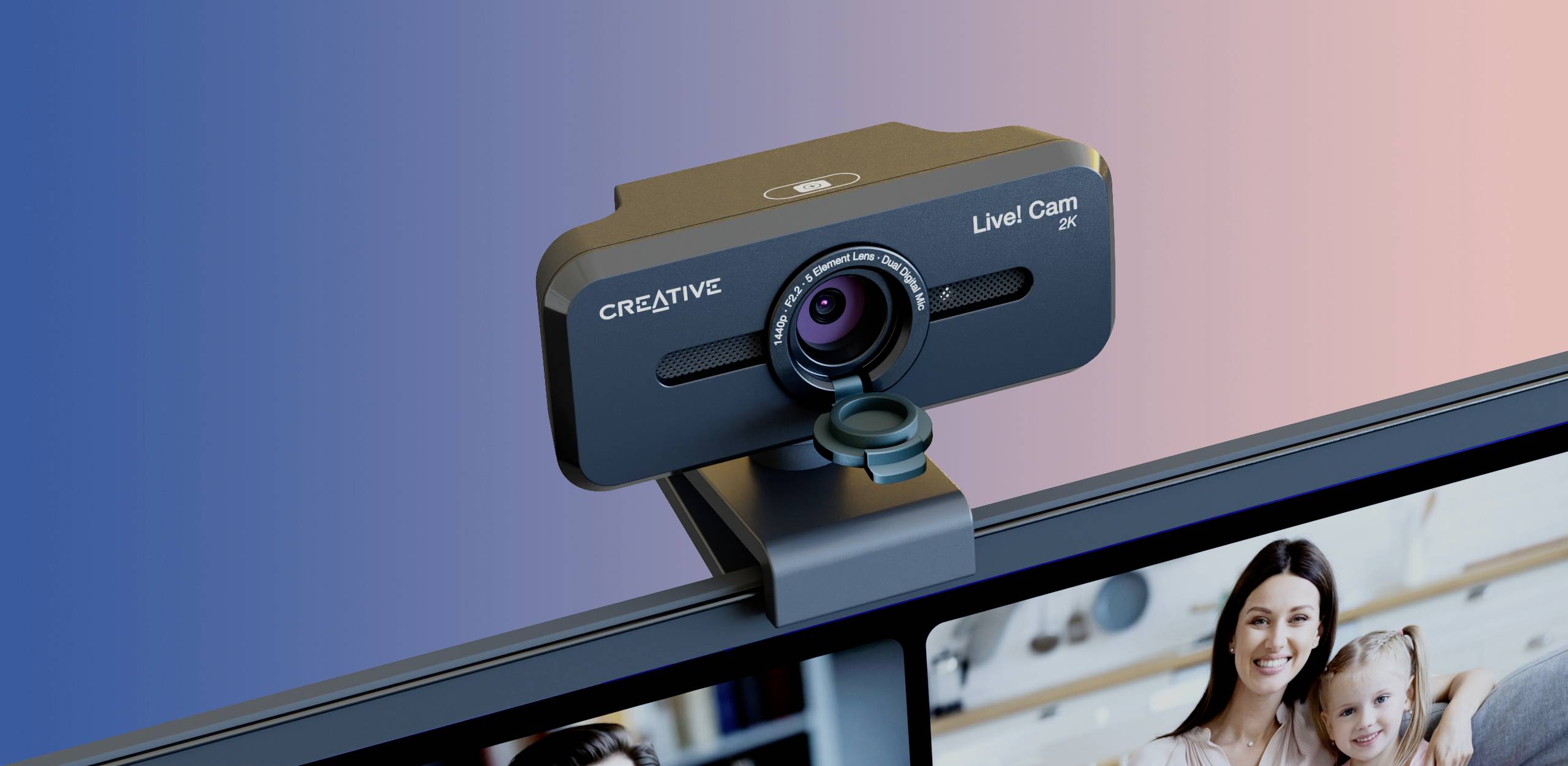 Creative brand webcam, 'Live! Cam' model, mounted on a computer monitor. Blurred colour gradients in the background.