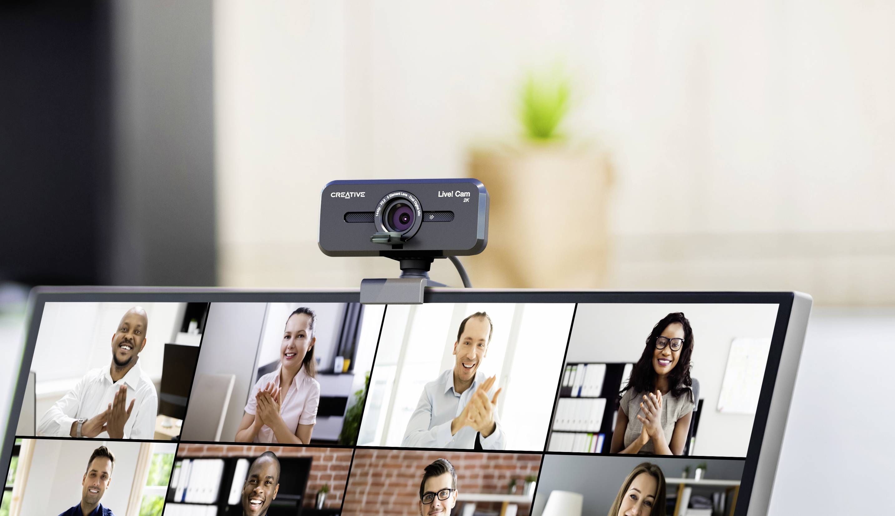 Several people in a video conference meeting on a computer screen, all smiling and clapping in front of their webcams.