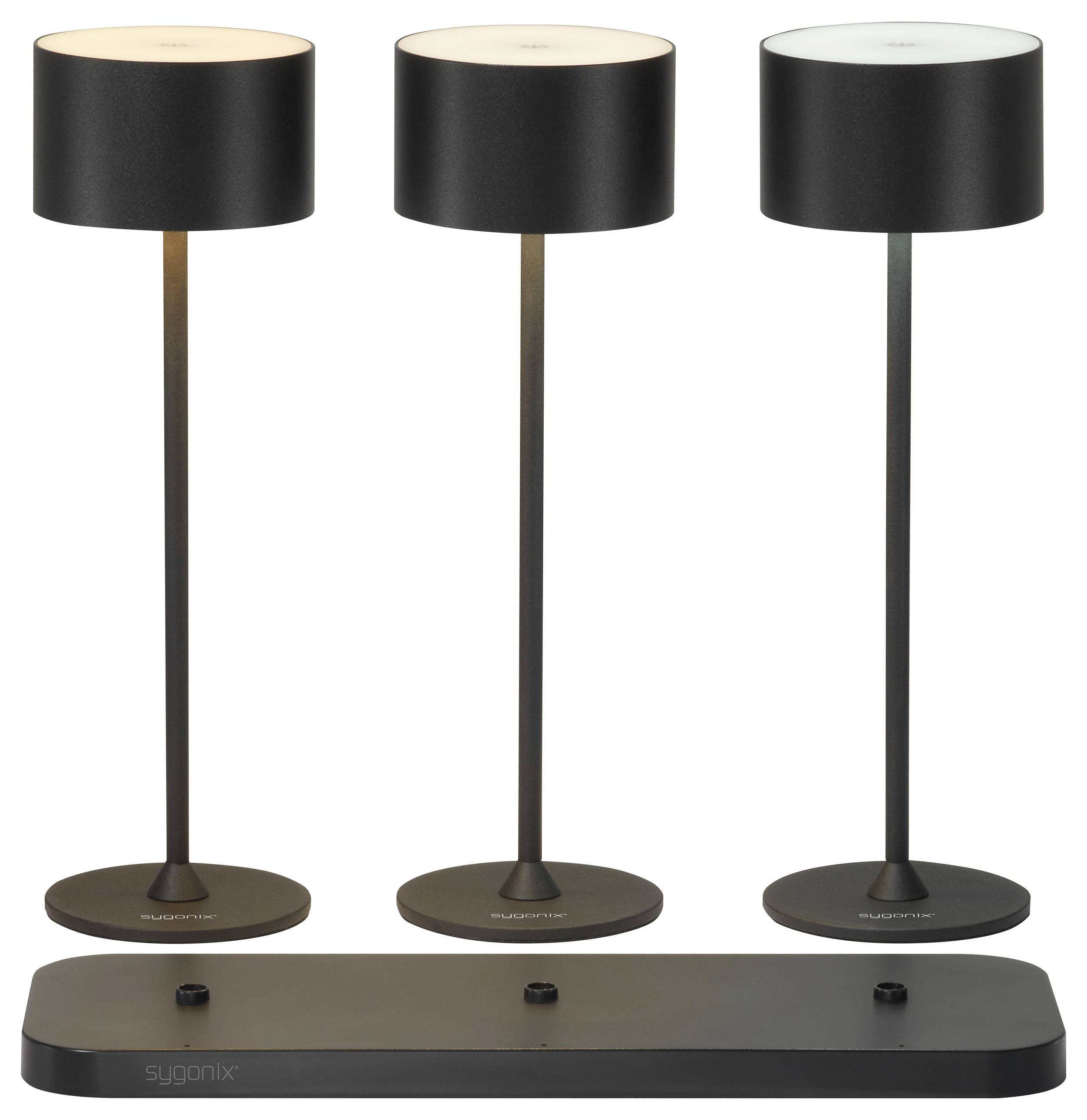 Three black table lamps in a row, with simple design, standing on a dark base plate, suitable for modern interior design.