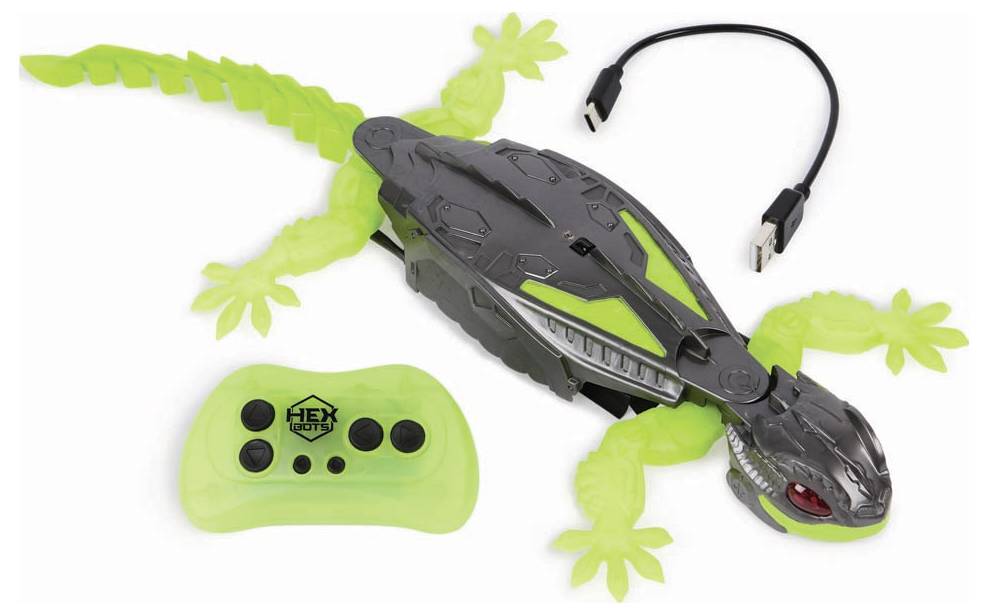 Toy lizard with a green body and black back, remote control, and charging cable.