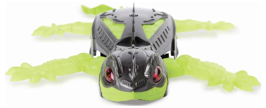 Black and green toy reptile with movable limbs and bright red eyes.