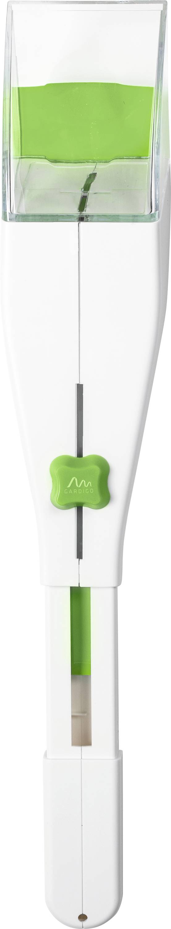 A white and green rice cooker measuring spoon with a narrow, rectangular container at the handle end. The container is filled with green rice.