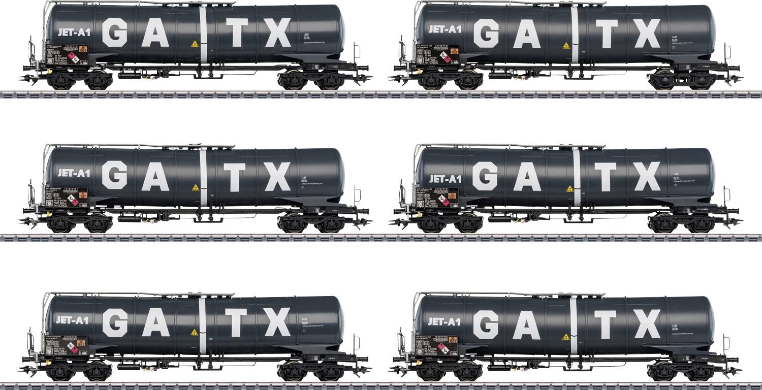 Six black tank wagons with the inscription 'GATX' on railway tracks. All wagons are parallel and identically aligned.