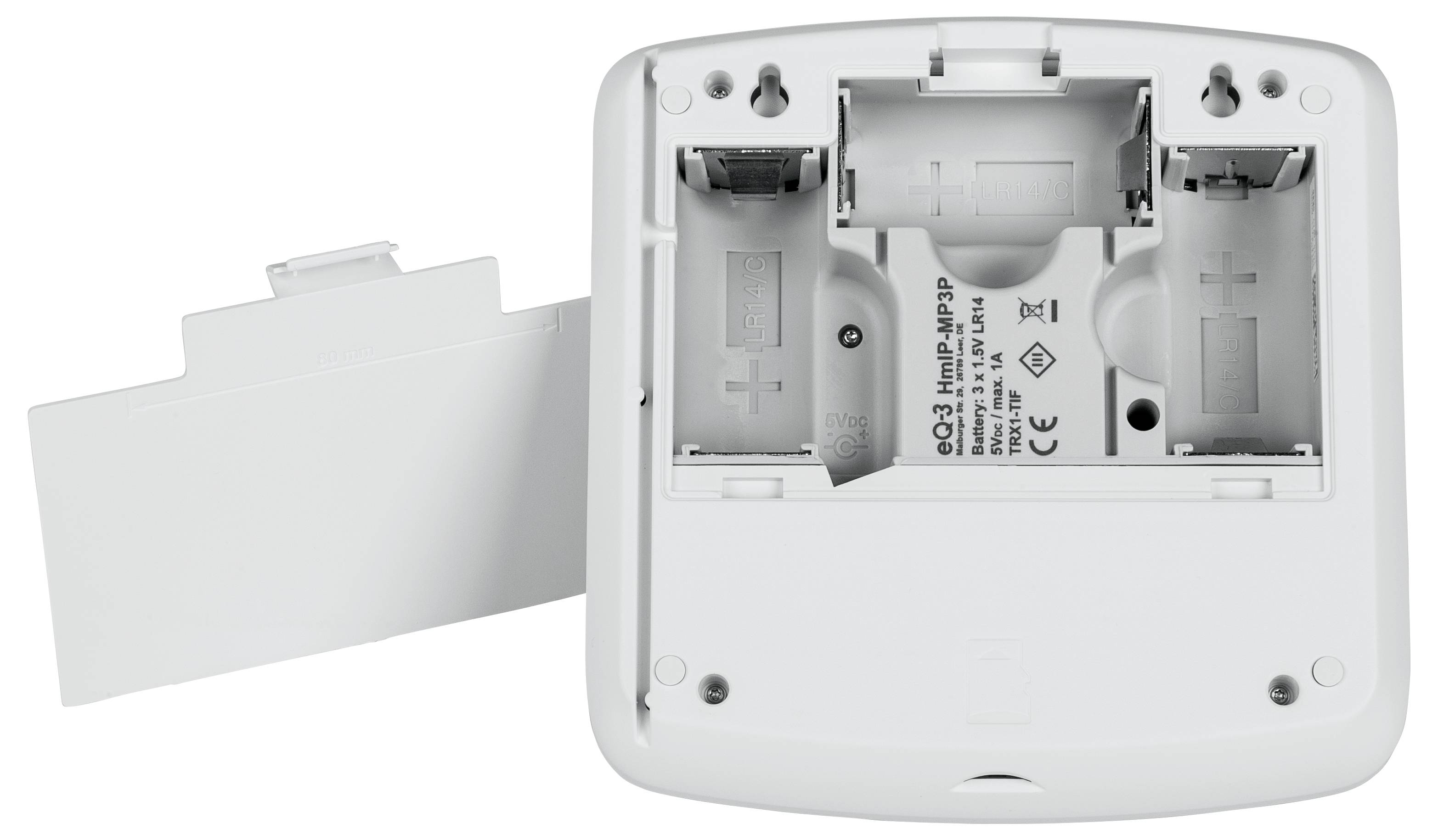 An open battery compartment of a white device capable of holding two AA batteries; the cover is lying beside it.