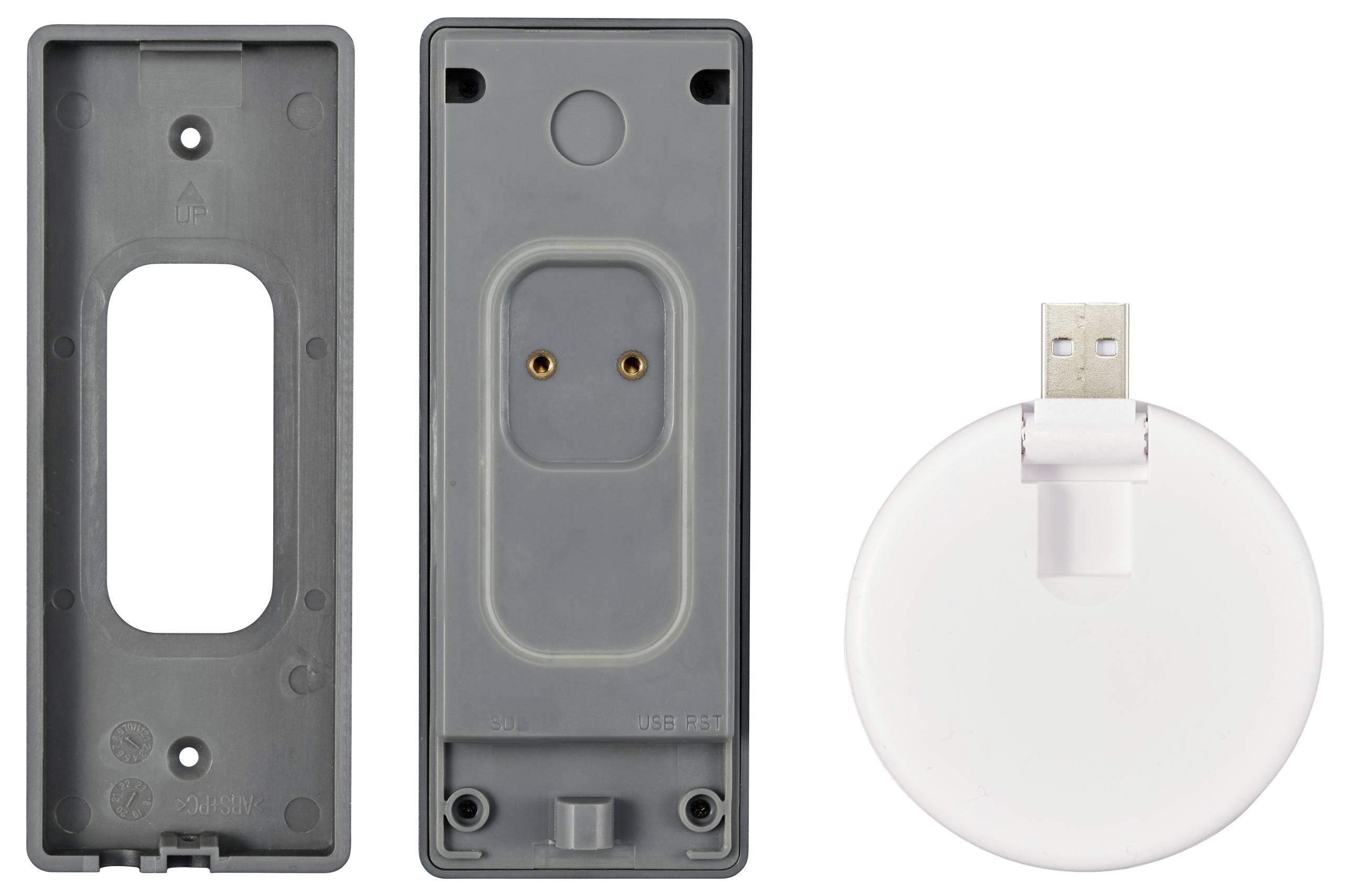Graues Plastikgehäuse in zwei Teilen neben einem weißen, runden USB-Ladedock. Die Rückseite zeigt Metallkontakte im Inneren.