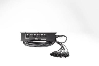 A black distribution box with multiple cables and plug connections. Connections are labelled with pictograms.