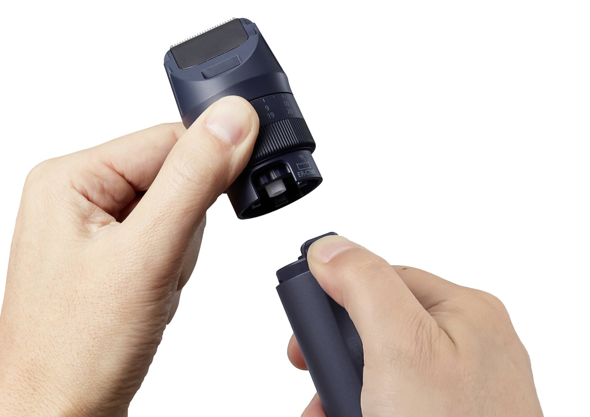 Two hands are holding parts of a razor, with the upper and lower sections being separated.