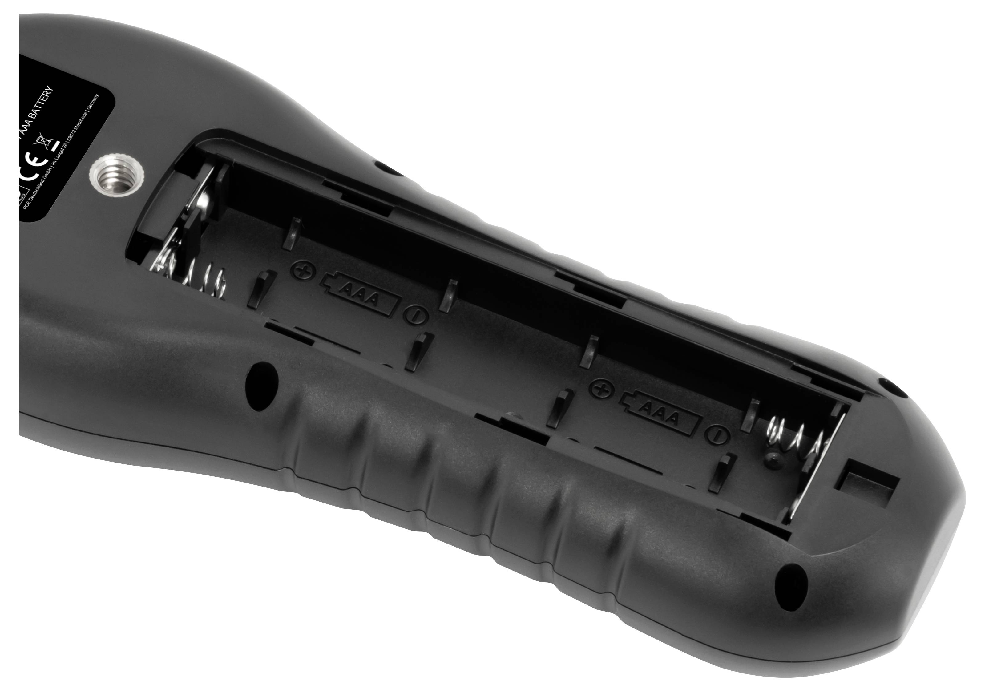 Open battery compartment on the underside of a black electronic device, showing slots for two AA batteries and spring contacts.