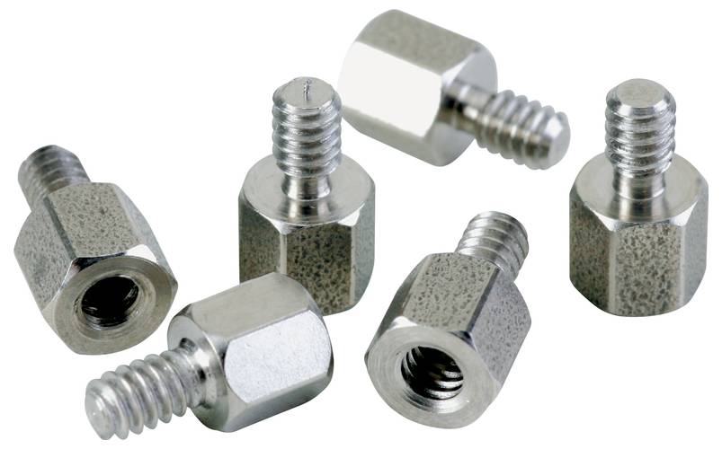 Six silver threaded spacers distributed across a white surface. They are made of metal and have a hexagonal shape.