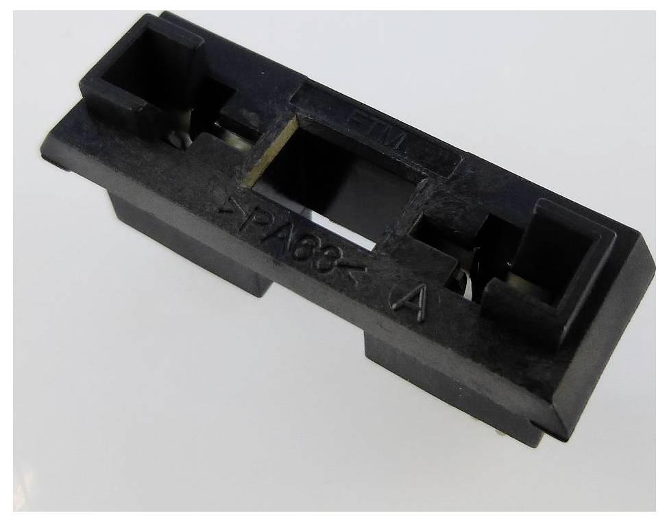 A black, rectangular plastic component with the embossing 'ETM' and 'PA66 A', lying on a white surface.