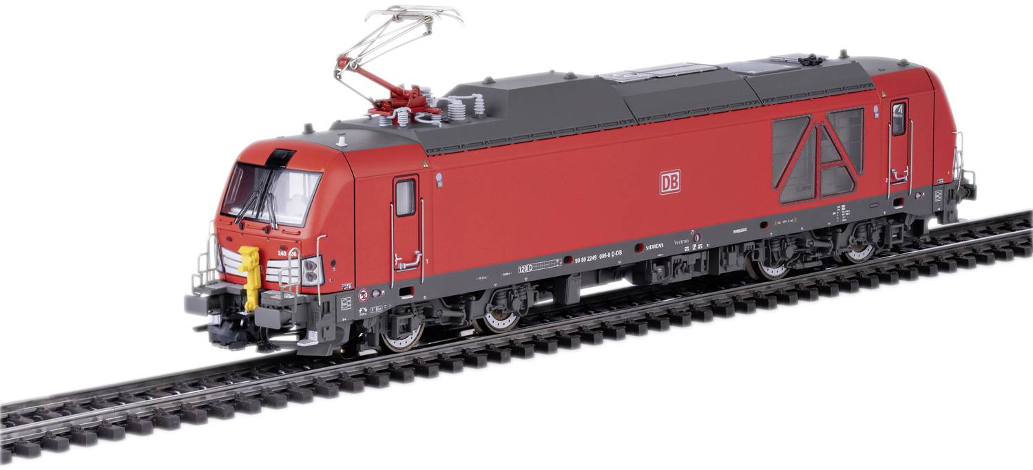 A red electric locomotive is travelling on a railway track.