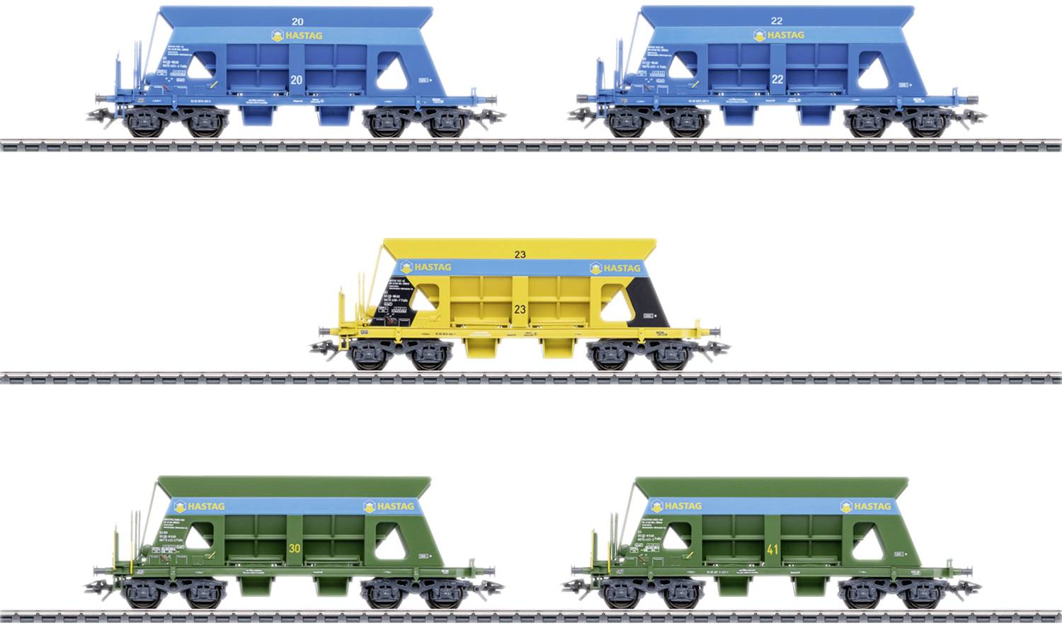 Five model freight trains in blue, yellow, and green colours on railway tracks, each labelled with different numbering.