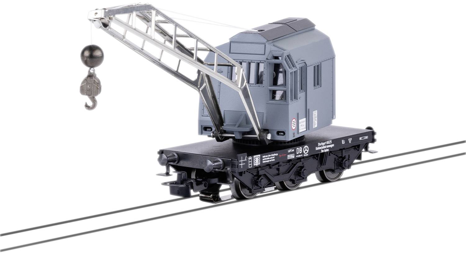 Toy model of a railway turntable crane in grey on railway tracks. The crane has a hook for lifting loads and is intricately designed.