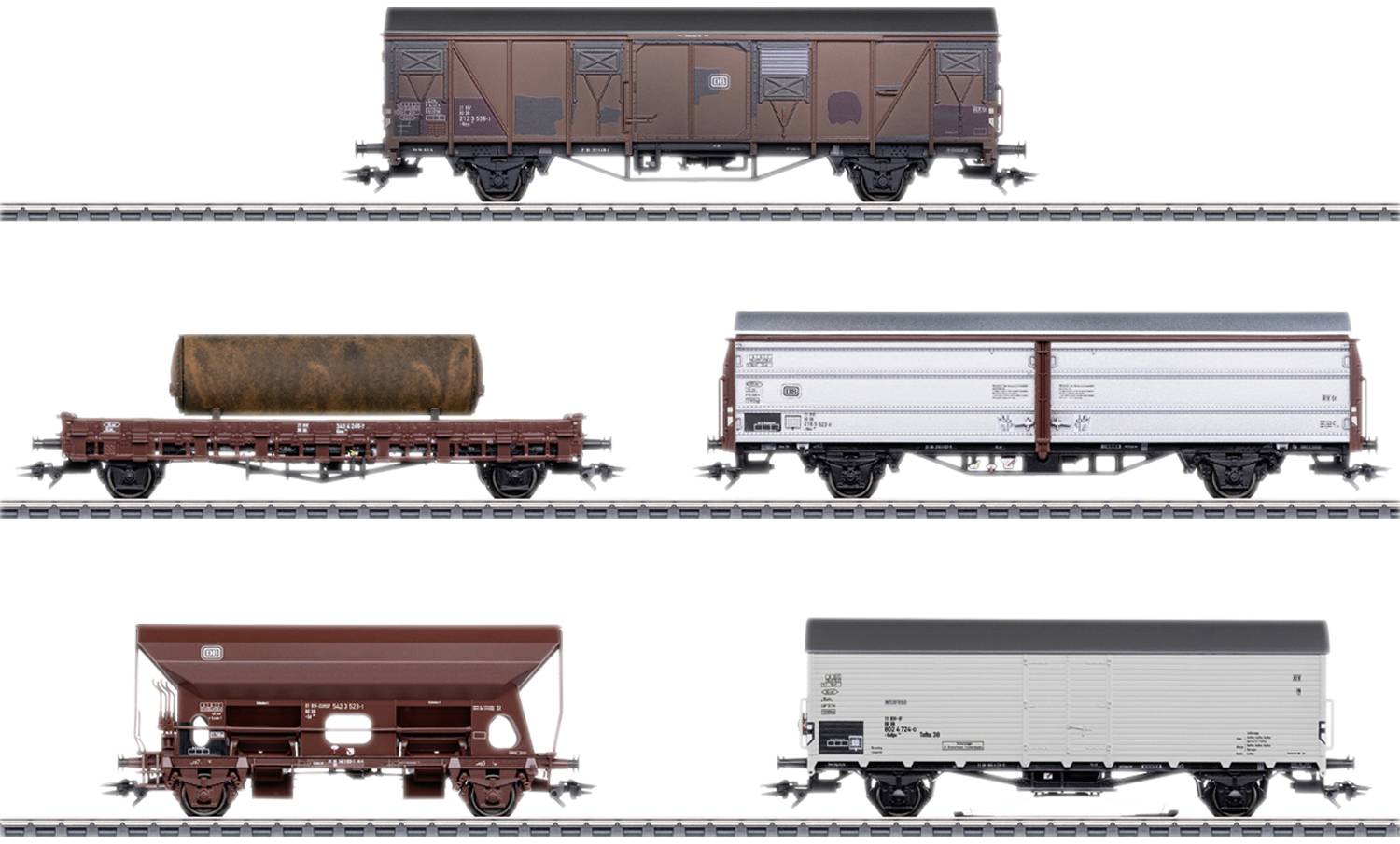 Five different goods wagons on railway tracks: closed, open with cargo, covered bulk wagon. Model railway scene.