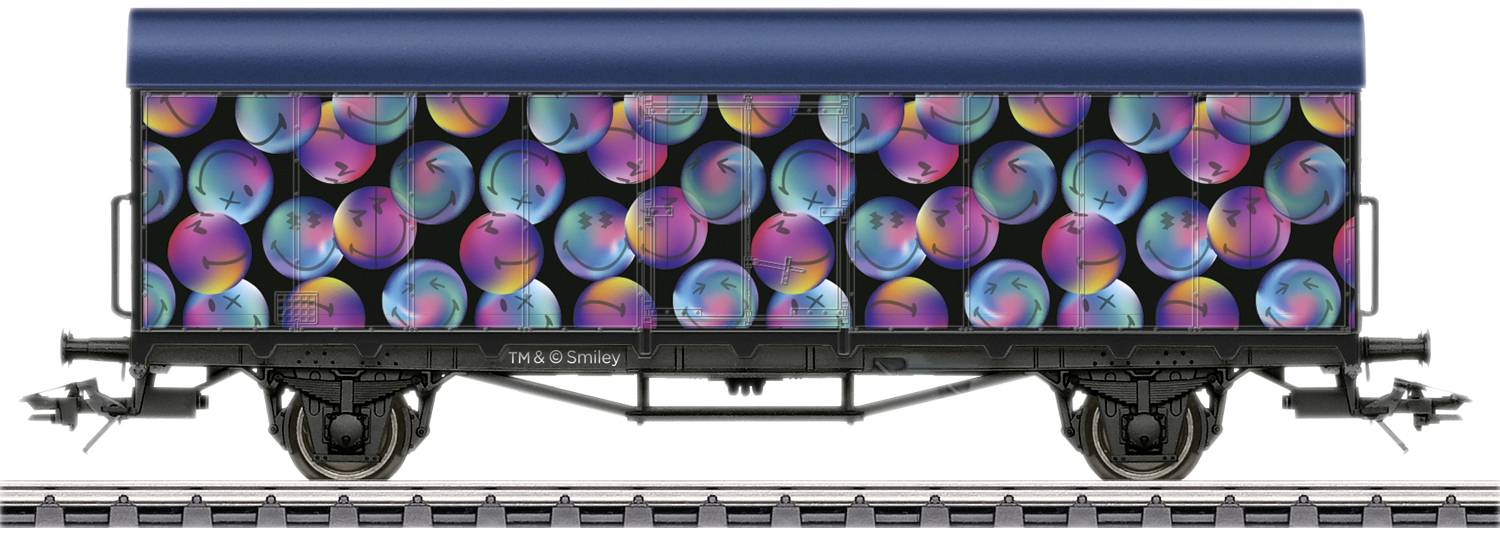 A goods wagon with a black body, printed with colourful, neon-coloured, spherical patterns.