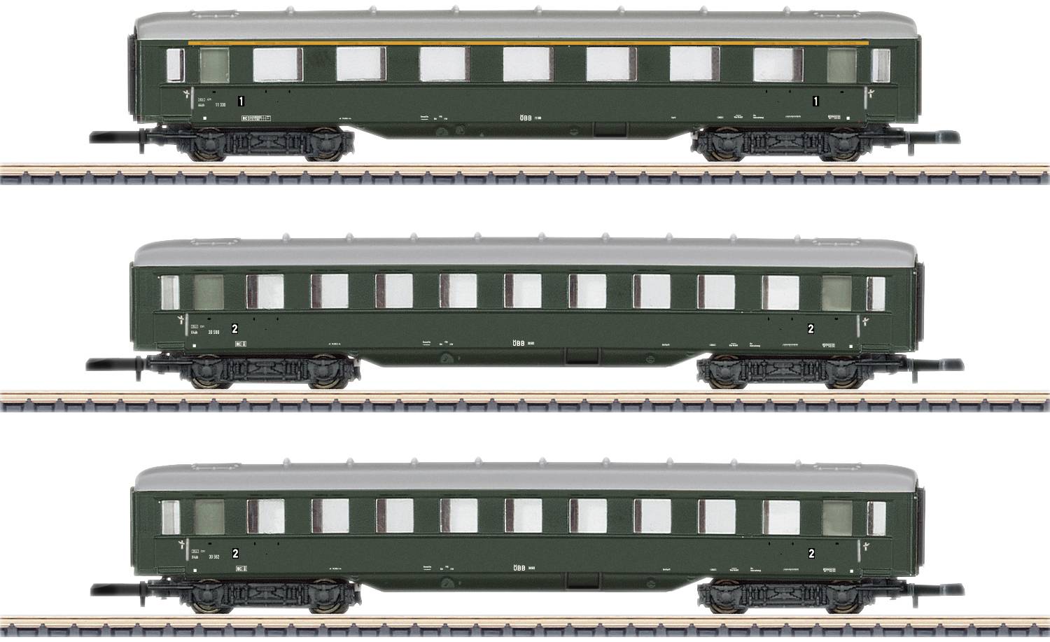 Three green model railway passenger carriages on tracks, arranged vertically from top to bottom. Each carriage has windows and a white roof line.