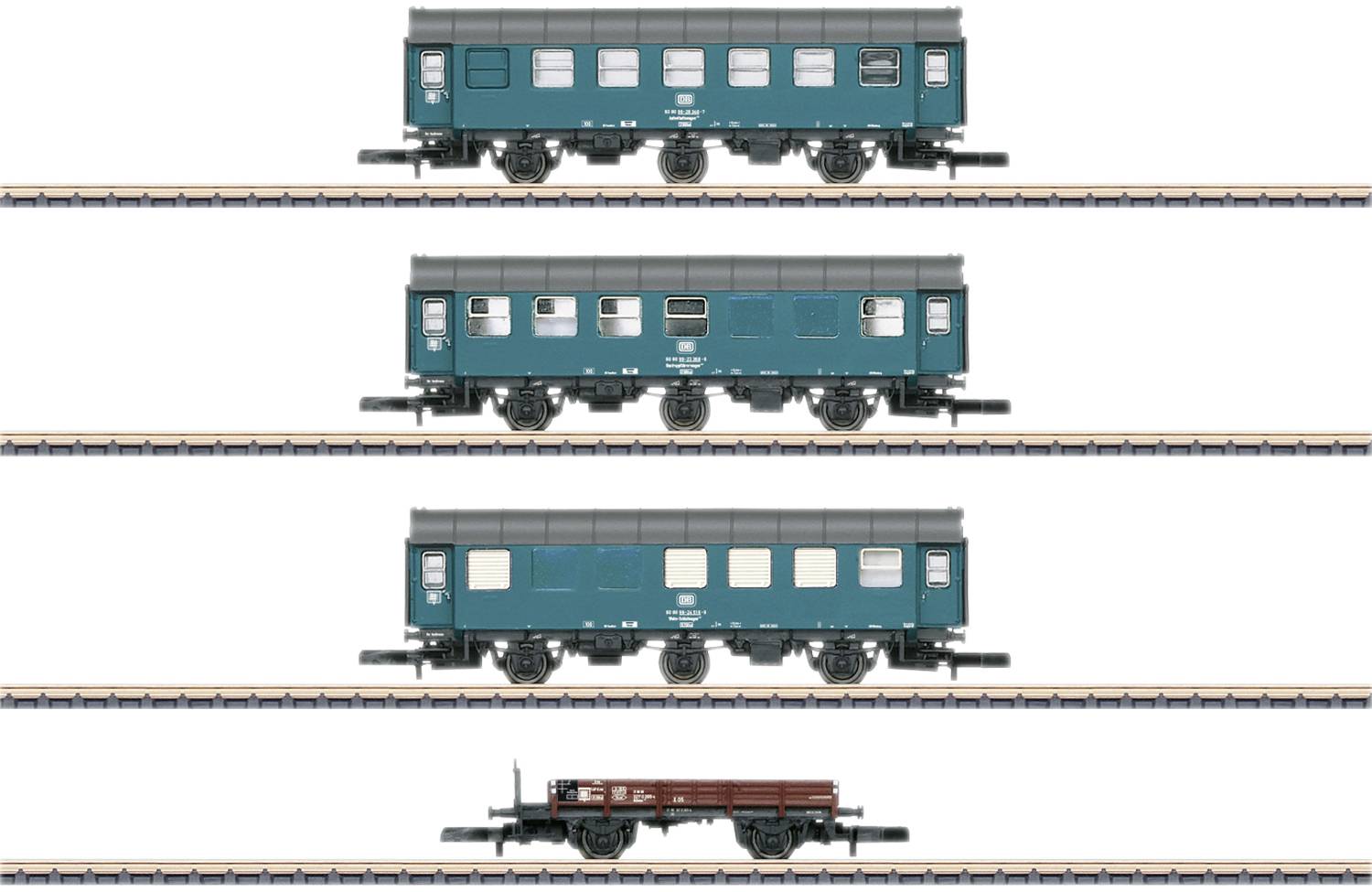 Four model railway carriages on tracks: three green passenger train carriages and a brown goods wagon in a row.