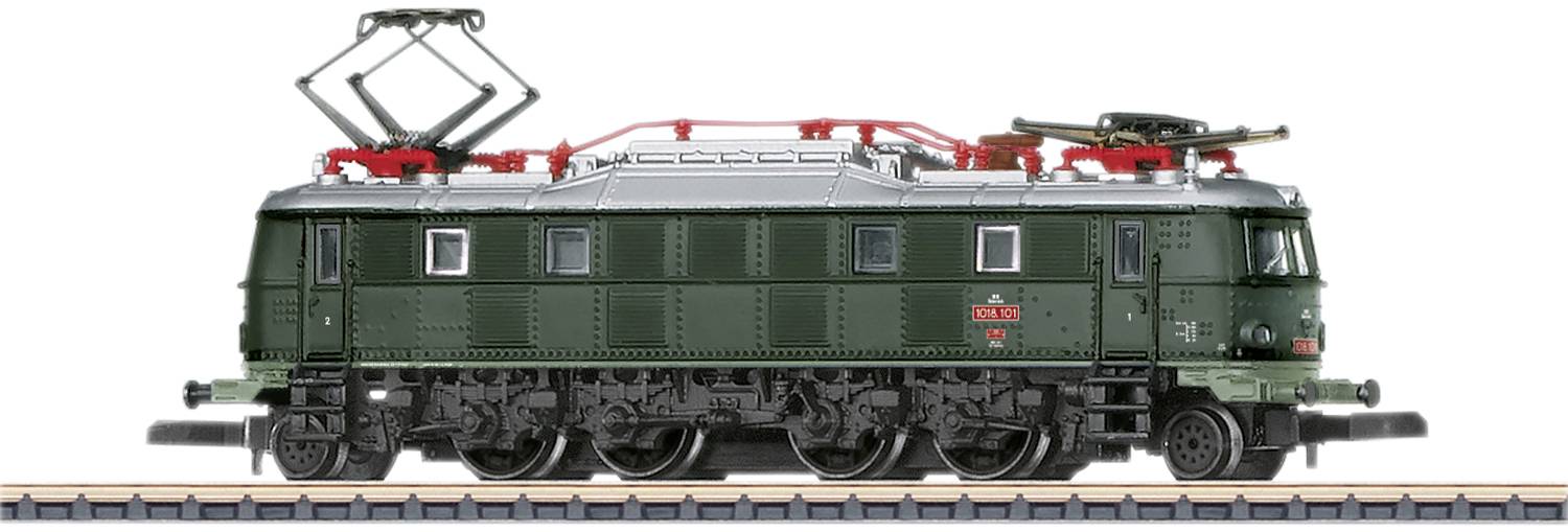 A green model electric locomotive is standing on a track. The locomotive has red pantographs and detailed components.