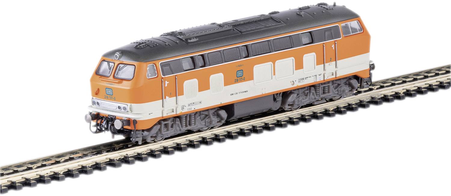 An orange and white Deutsche Bahn model train is travelling on a track. The train has a black roof and distinctive window rows.