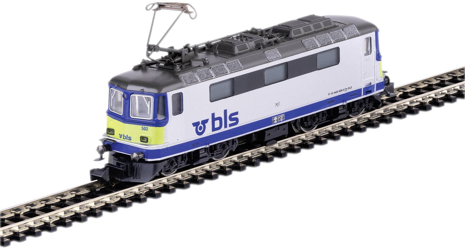 A blue and white model train with 'BLS' written on it is travelling on a railway track. The train has a pantographic current collector structure.