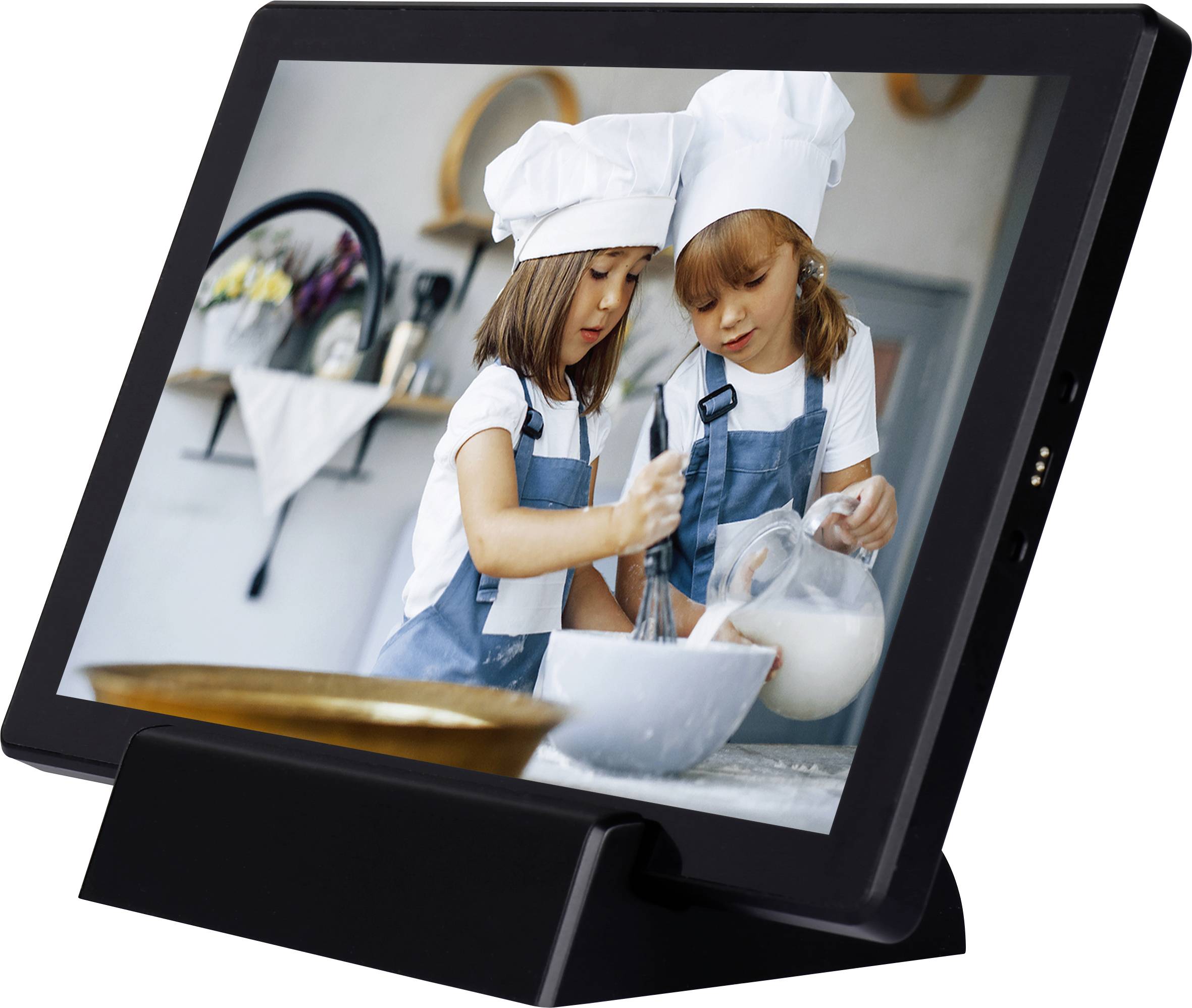Two girls in chef's hats and aprons are mixing flour and milk in a kitchen. One girl is holding a whisk, the other a jug.