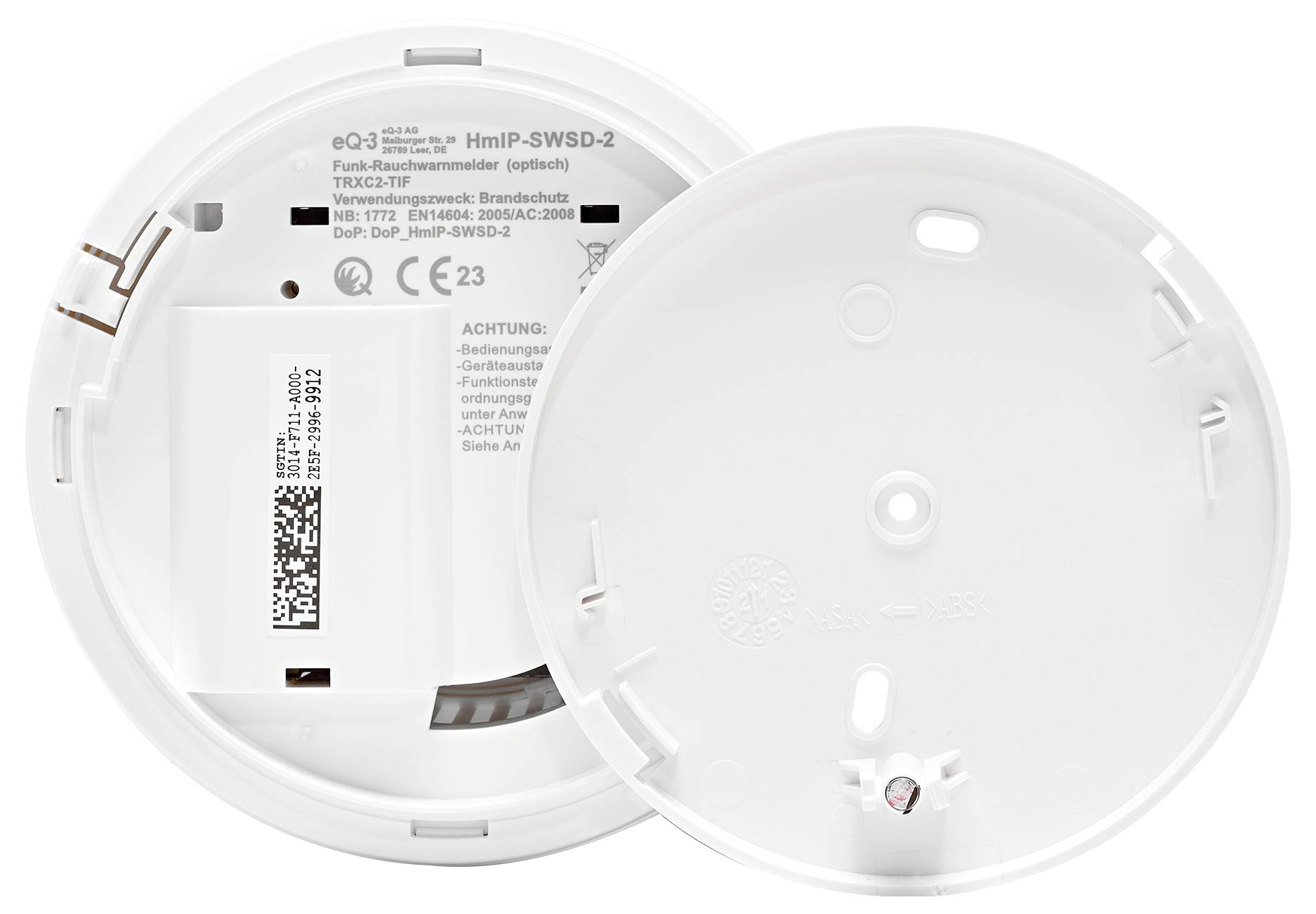 Smoke detector with removed back panel revealing battery compartment and QR code inside. Device used for fire protection.