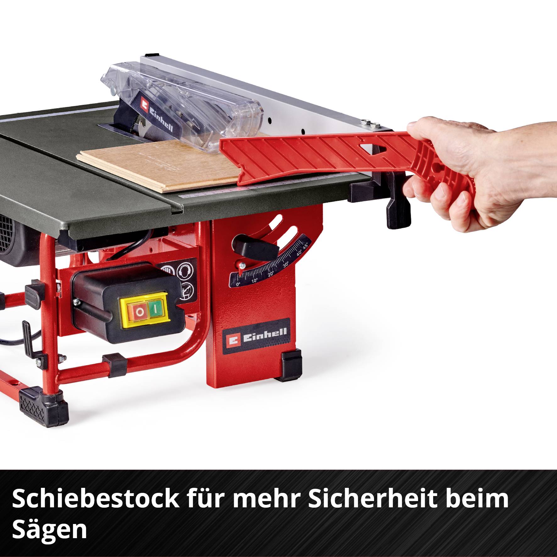 A red table circular saw with a hand holding a red push stick to guide a plank. Text at the bottom: 'Push stick for increased safety when sawing'.