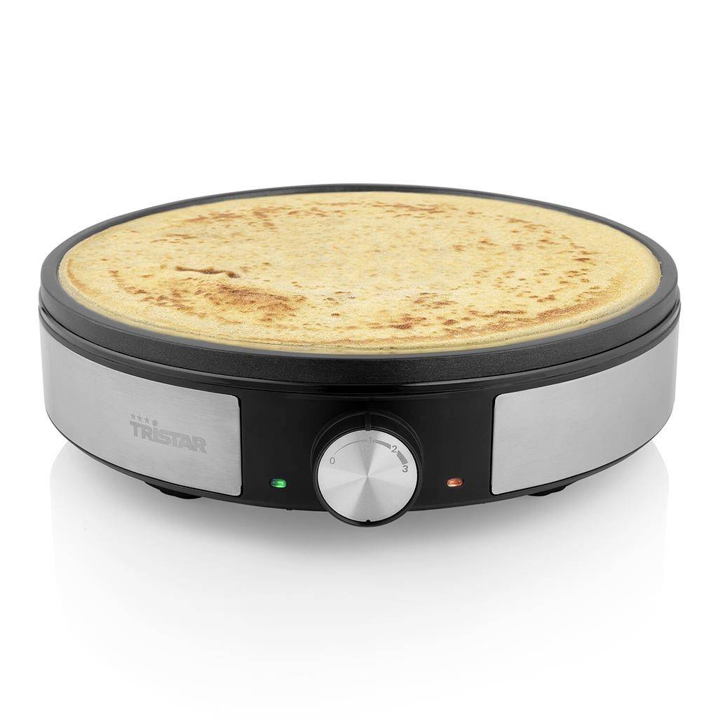 Electric crêpe maker with a golden-brown crêpe in the centre. Two indicator lights and a rotary control knob are located at the front.