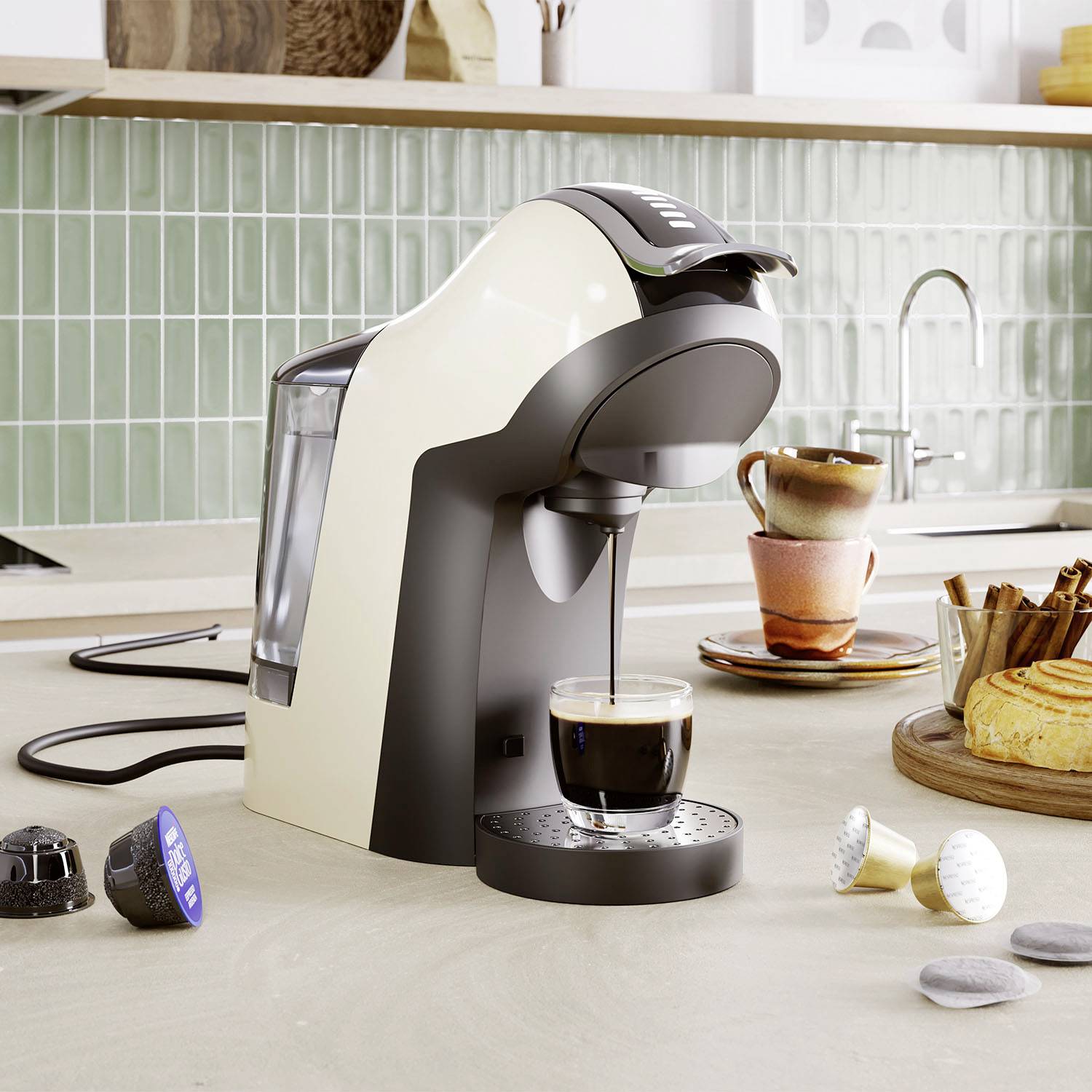 Coffee machine on a kitchen worktop preparing an espresso. Beside it are cups, coffee capsules, and a pastry.