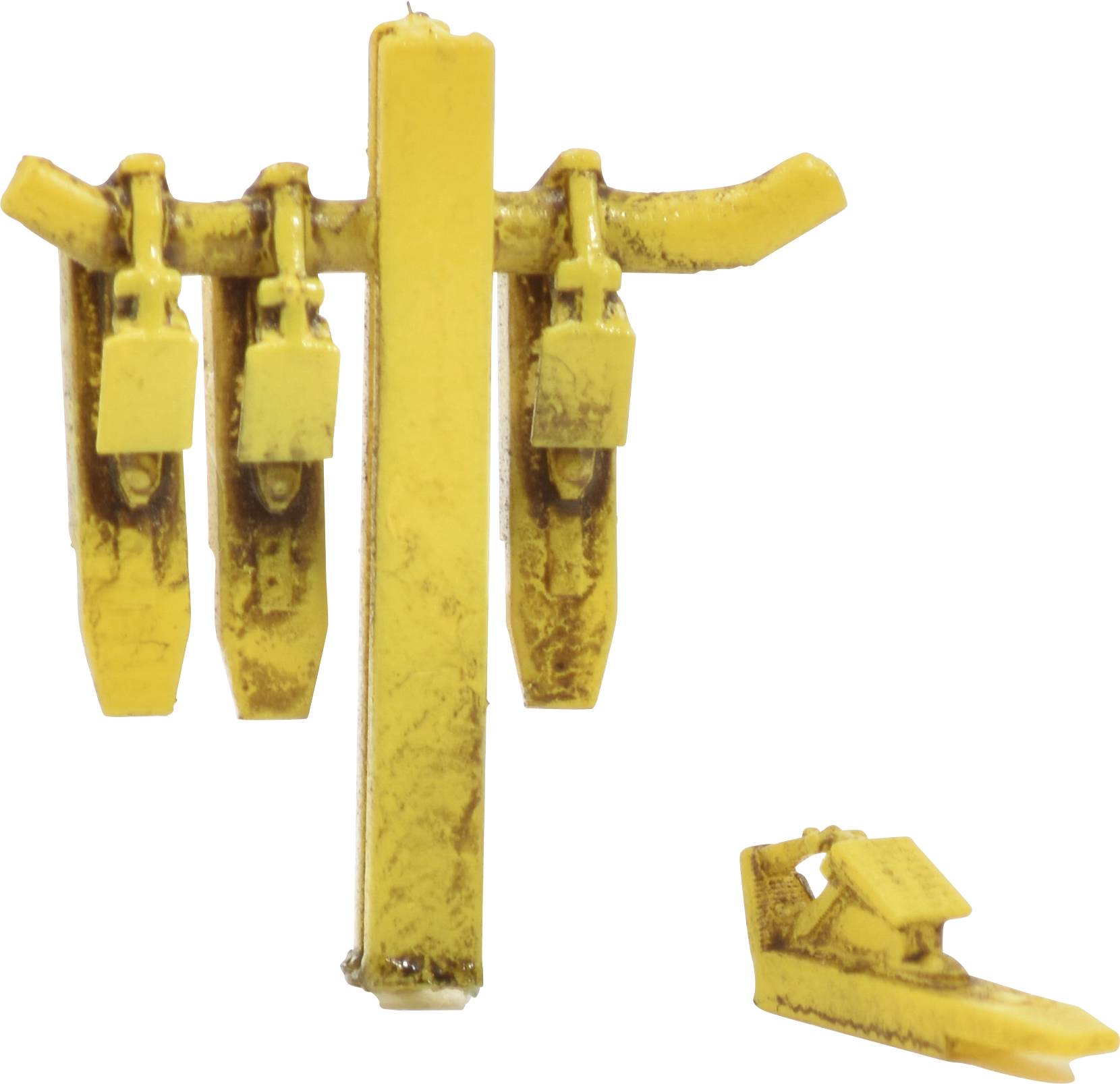 A yellow metal device with three vertical supports and hooks. Beside it lies a lowered, single piece with a hook.