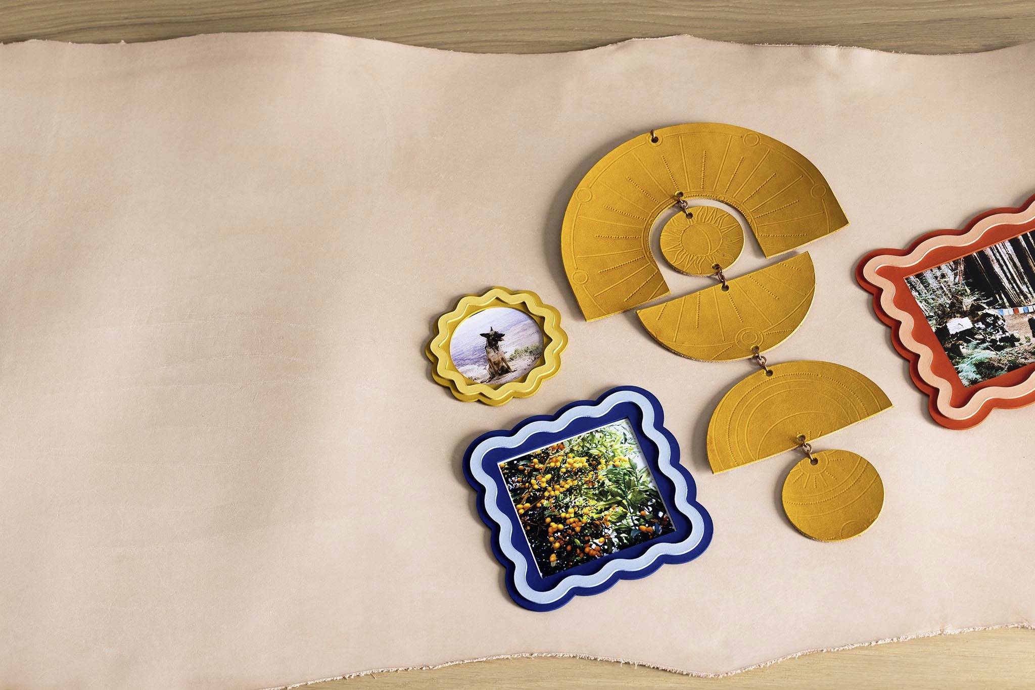 Various coloured frames with nature photographs, arranged on a beige cloth. The focus is on the images and the creative arrangement.