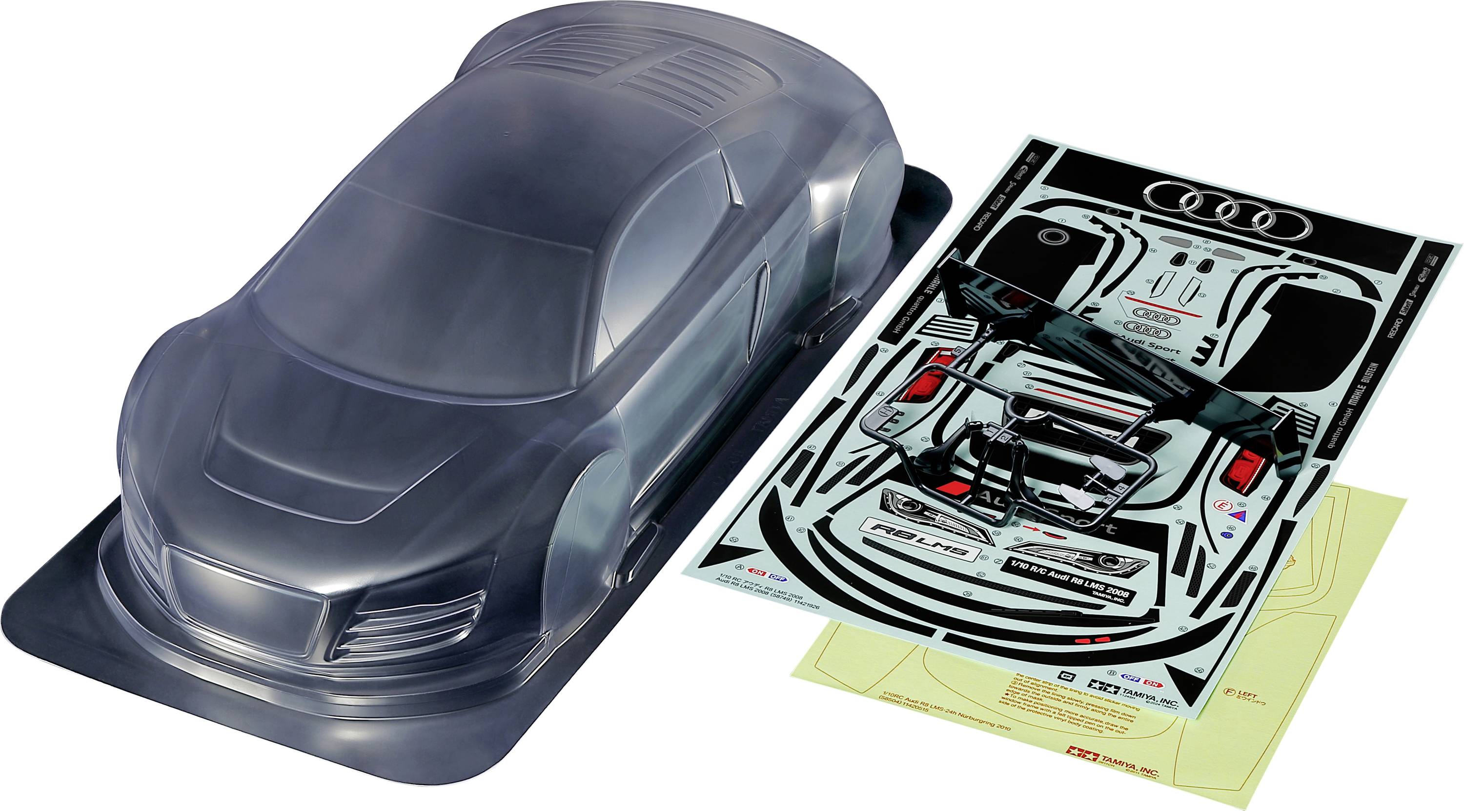 A clear model car kit with Audi design stickers beside it. Includes unpainted bodywork and detailed sticker sheets.
