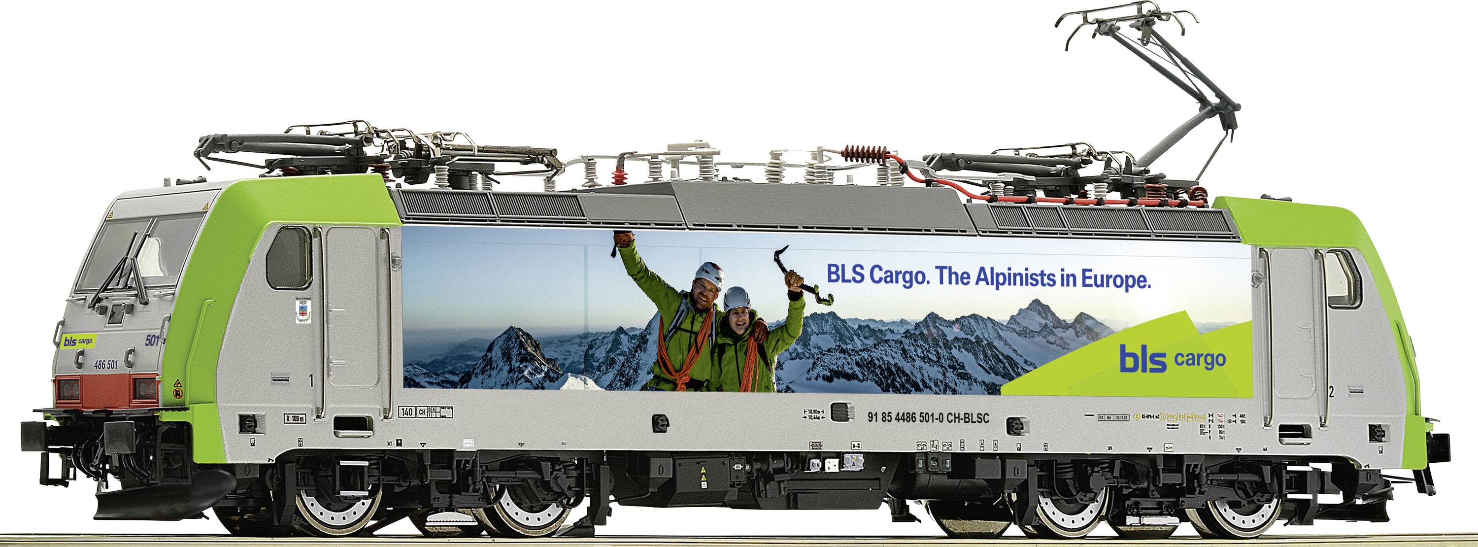 Ein Modellzug mit grünem und silbernem Design. An der Seite ist ein Foto von zwei lachenden Personen vor schneebedeckten Bergen. Aufschrift: 'BLS Cargo. The Alpenists in Europe.'