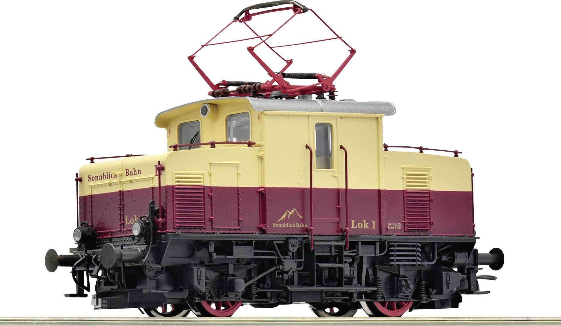 Small model locomotive, painted red and yellow with the inscription 'Simmentalbahn'. It has a pantograph on the roof.