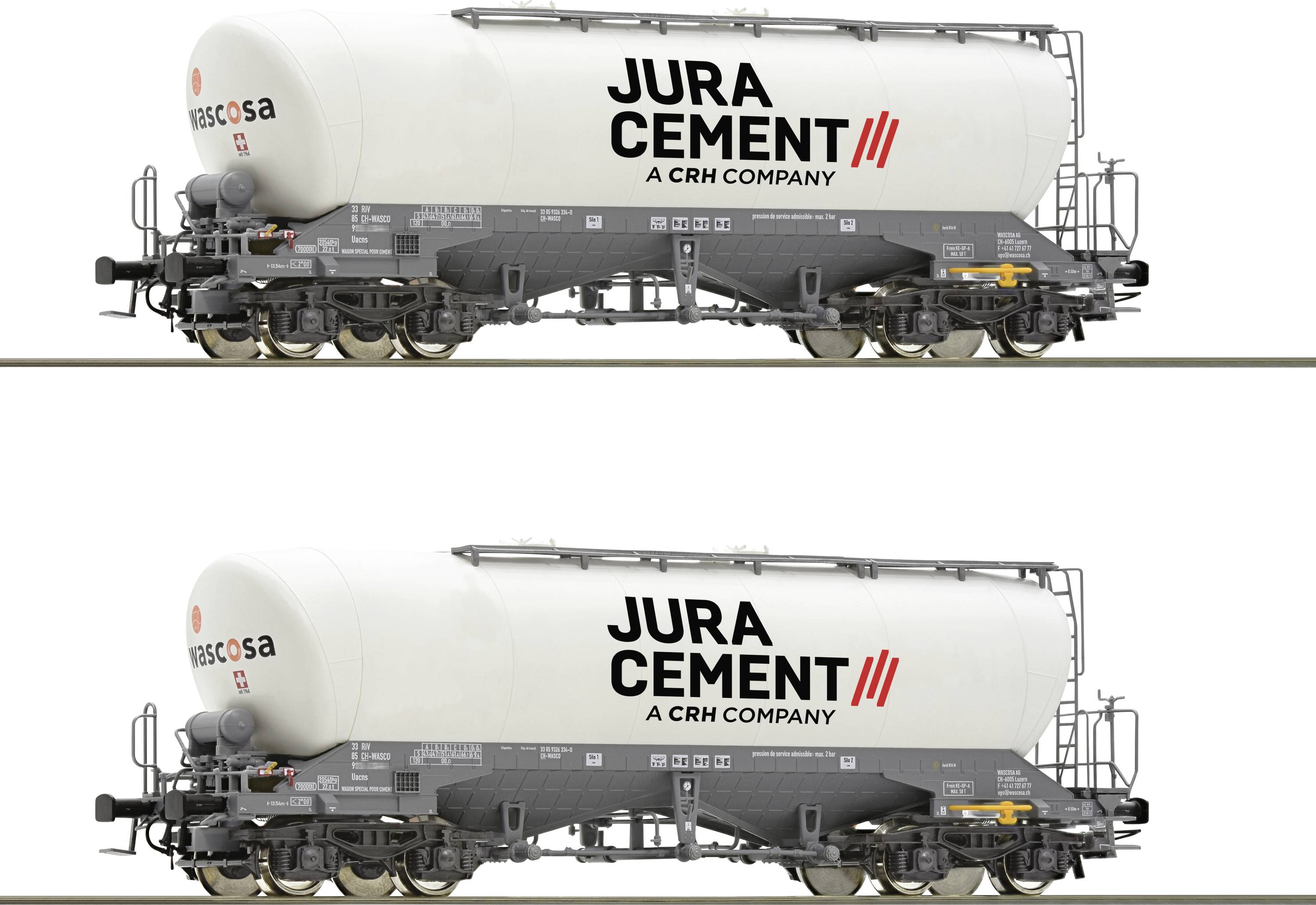 Two freight wagons with the inscription 'Jura Cement'. The wagons are white and are standing on railway tracks.