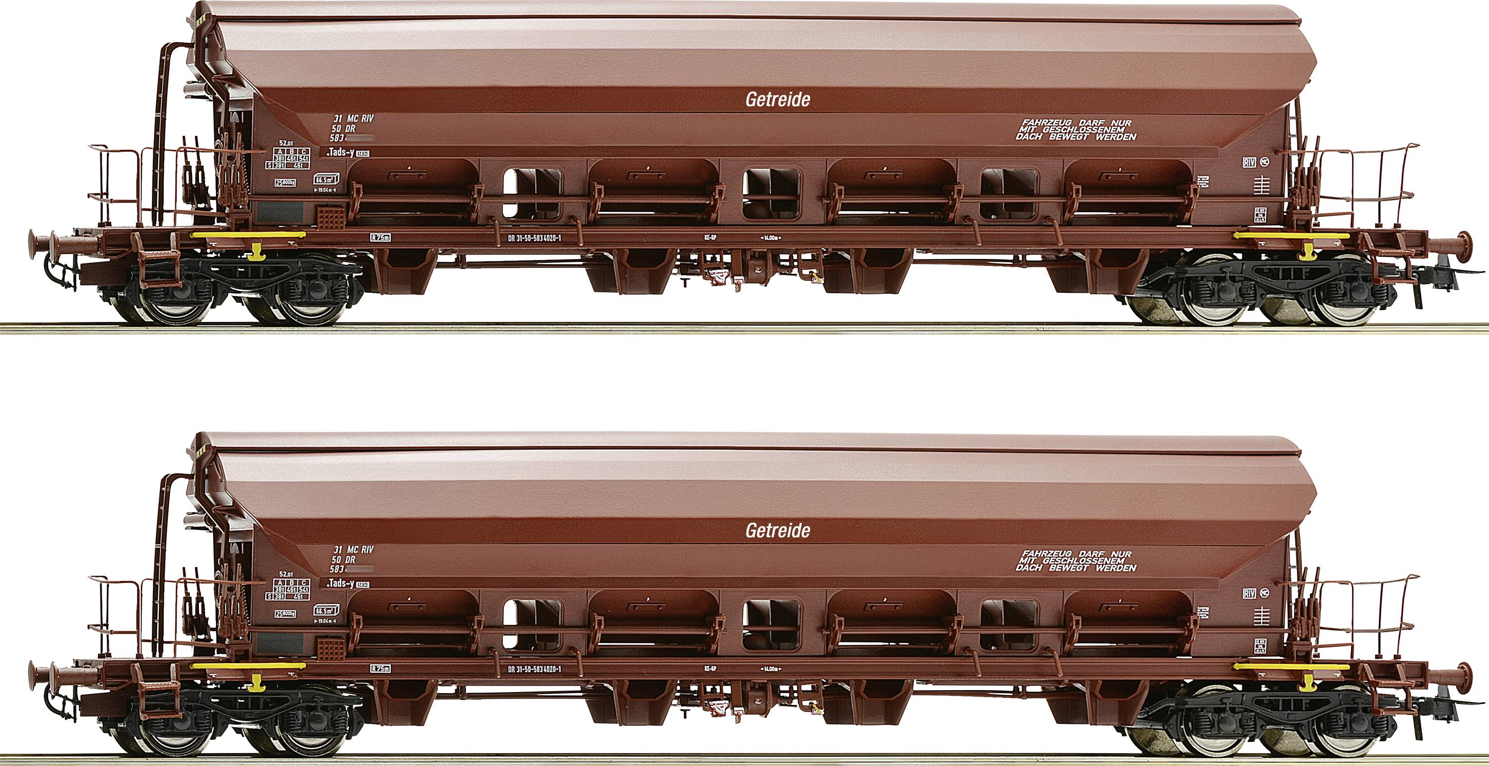 Two brown grain wagons are standing on railway tracks. Both wagons have a similar construction with the inscription 'Grain'.