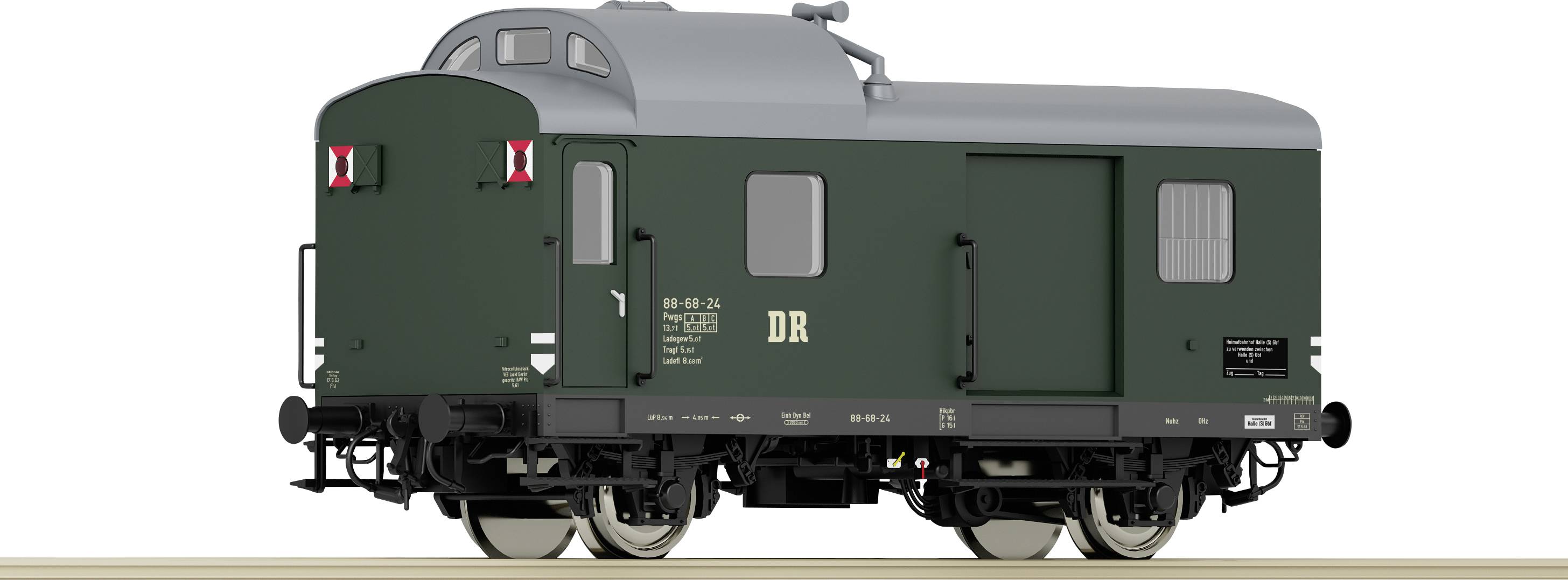 Green, four-axle locomotive of the Deutsche Reichsbahn with a grey roof on a light brown track, side view.