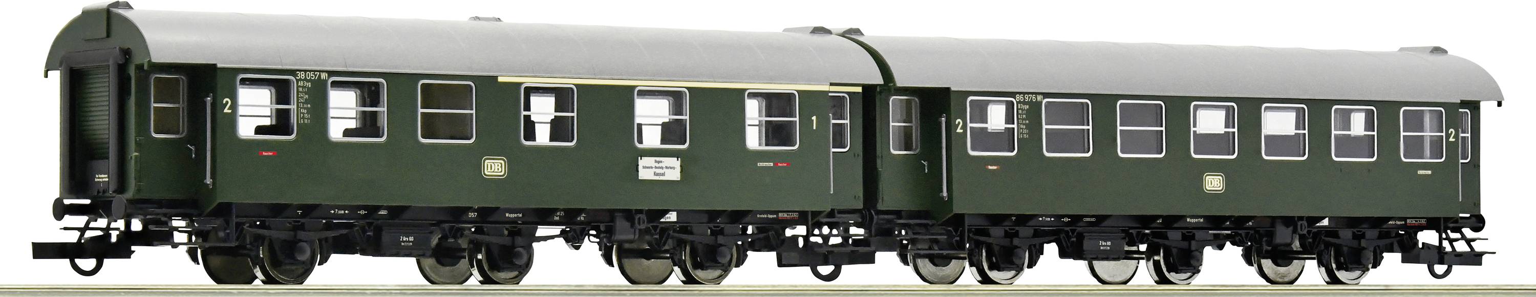 Two dark green, historic passenger carriages on rails, standing side by side, with multiple windows and intricately painted details.