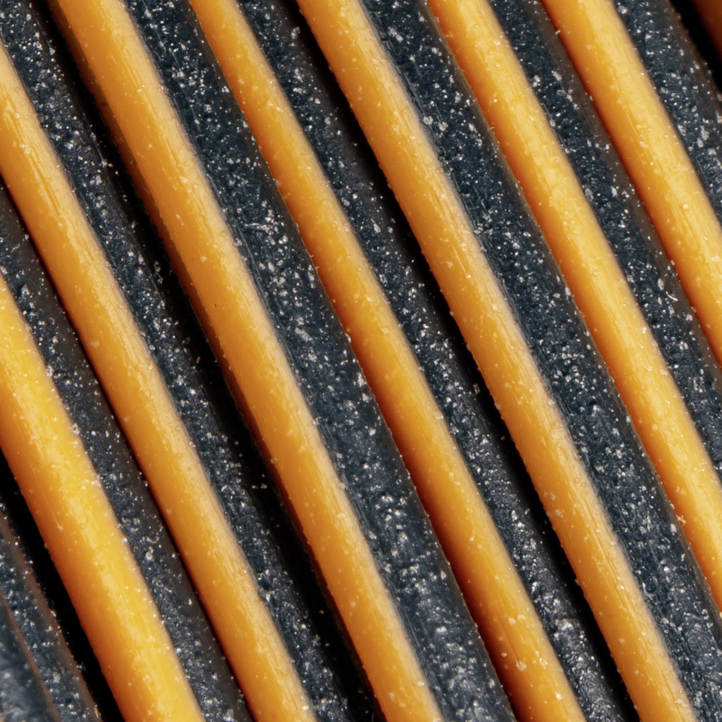 Close-up of orange and black stripes running parallel with a texture showing dust or crumbs.