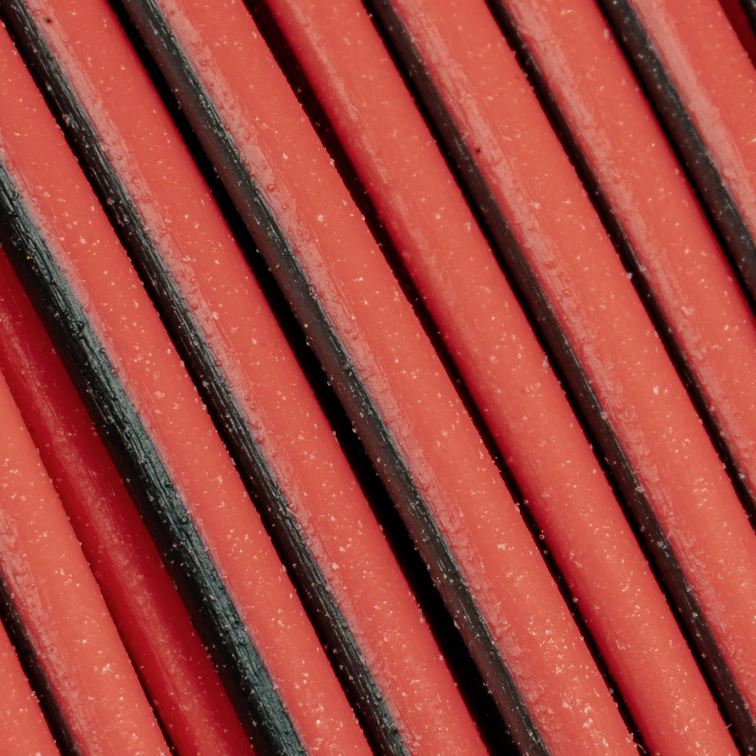 Close-up of several parallel orange cables arranged closely together, showing the texture of the surfaces.