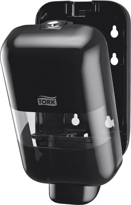 A black wall-mounted soap dispenser, slightly open, displays the 'Tork' brand logo.