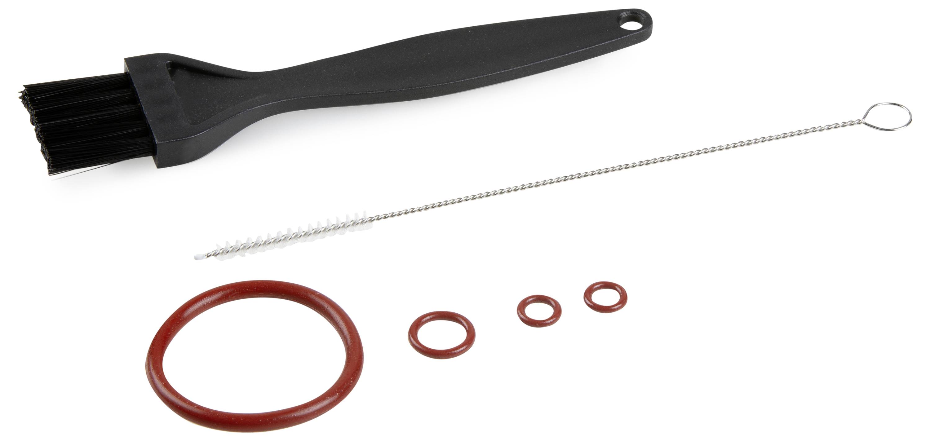 A black paintbrush, a thin cleaning brush and four red sealing rings in various sizes are lying on a white surface.