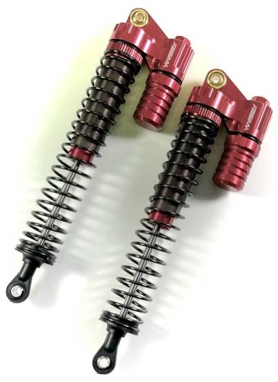 Two wire springs with red dampers lying side by side. They are designed for the suspension of vehicles or machines.