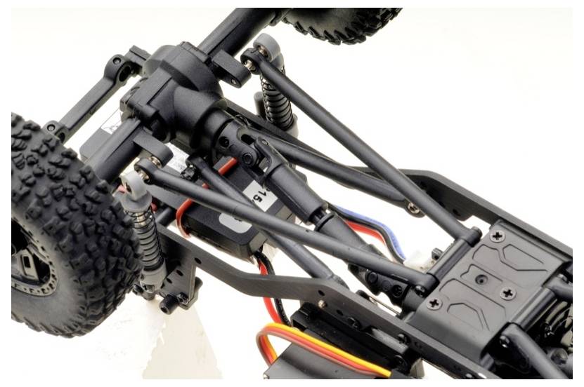 Close-up of a remote-controlled vehicle chassis with visible axle system, stabilisers, and wiring.