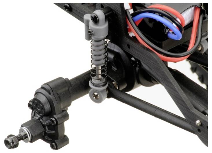 A close-up of a model car chassis with suspension and wiring. It shows a spring and stabiliser on a black frame.