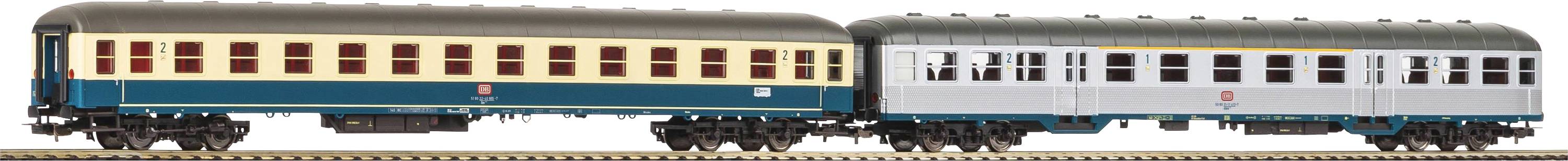 A model train with two differently coloured carriages on a track. The left carriage is beige and blue, the right one grey.